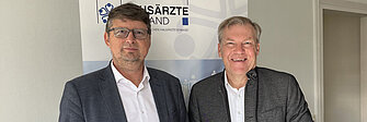 Dr. Wolfgang Ritter (Landesvositzender des BHÄV) und Dr. Ralf Langejürgen (Vorstandsvorsitzender BKK Landesverband Bayern) vor einem Rollup des BHÄV in der Münchner Geschäftsstelle des Bayerischen Hausärzteverbandes (BHÄV).