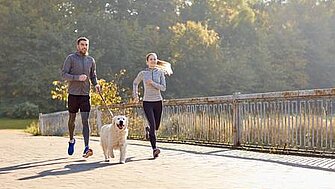 Paar joggt mit Hund