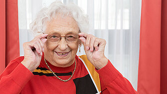 Seniorin schaut durch ihre Brille